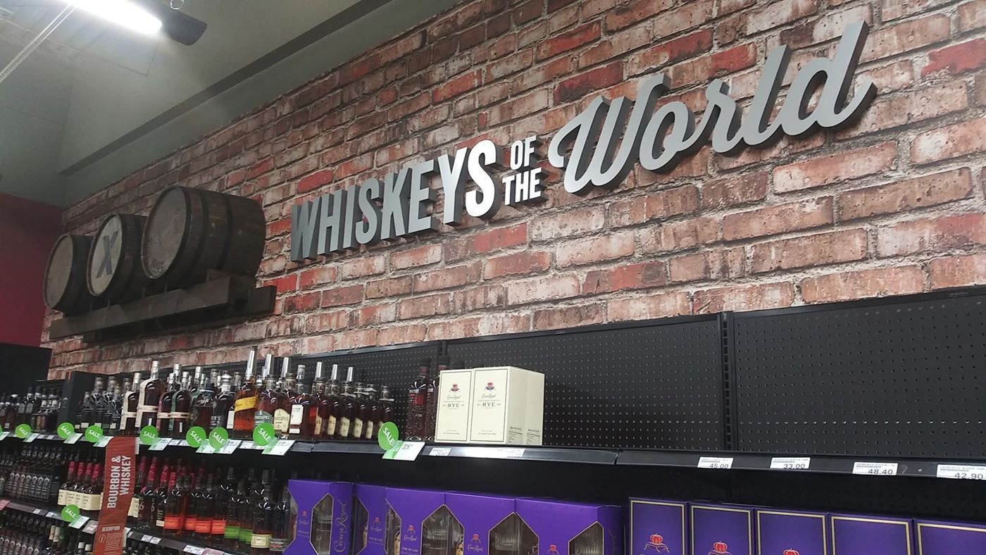 Whiskeys of the World dimensional sign installed on brick wall in a retail liquor store